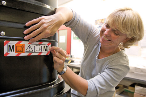Ruwac medewerkster van de Cosmetica-afdeling bij het aanbrengen van een sticker op een zuiger